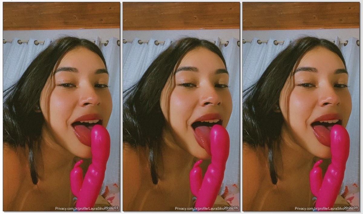 Laura Silva aparece na câmera sensualmente passando a língua no vibrador com uma expressão provocante