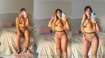 Gaby de Paula, conhecida do OnlyFans, posando de forma ousada no espelho sem calcinha, usando apenas meia calça