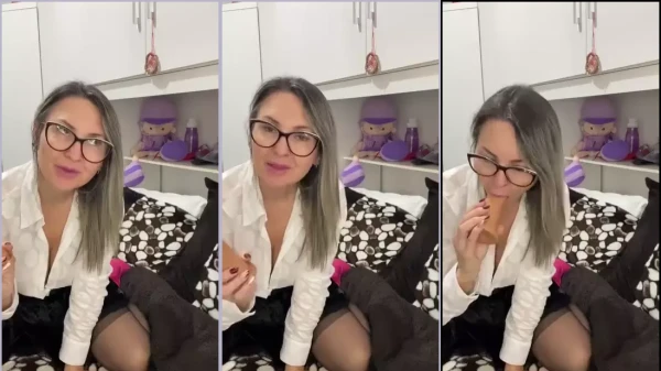 Professora Carla fazendo um oral no dildo com expressão provocante